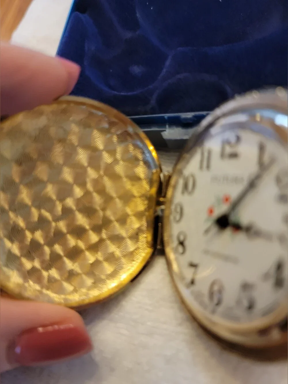 Vintage gold-tone pocket watch has a raised steam engine train motif.
